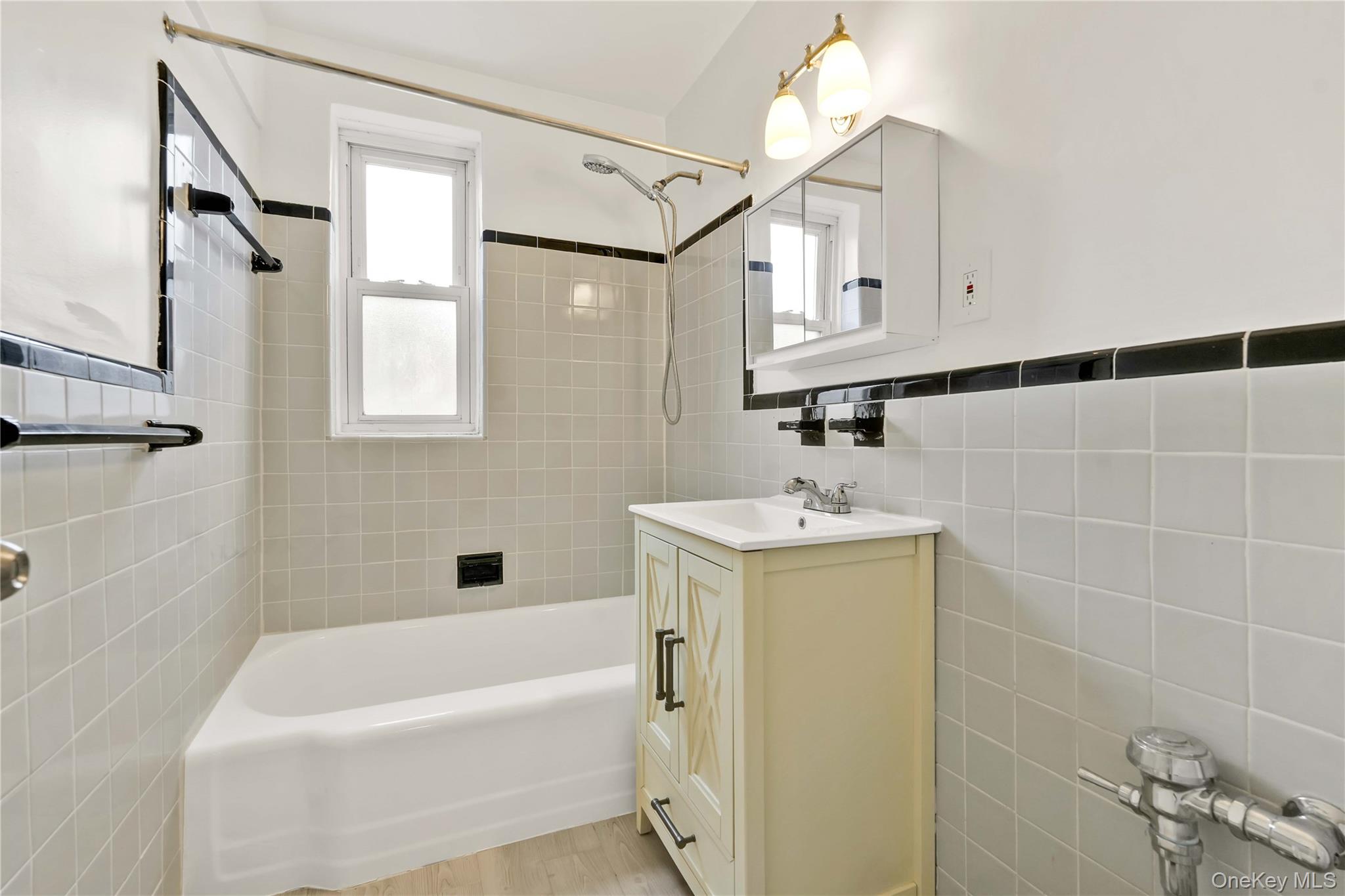 110-15 71st Road, Unit 6J Queens, NY 11375 - Photo 16 of 23 a bathroom with a bathtub a sink a window and vanity