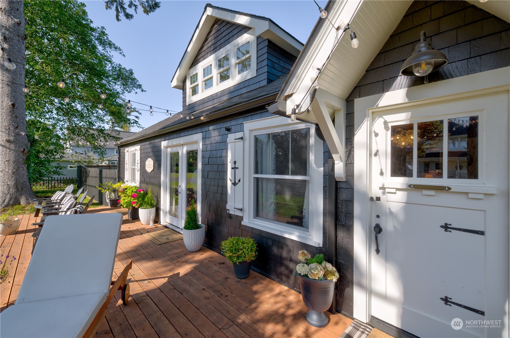 4202 L Place Seaview, WA 98644 - Photo 26 of 39 a view of a patio with table and chairs potted plants and floor to ceiling window