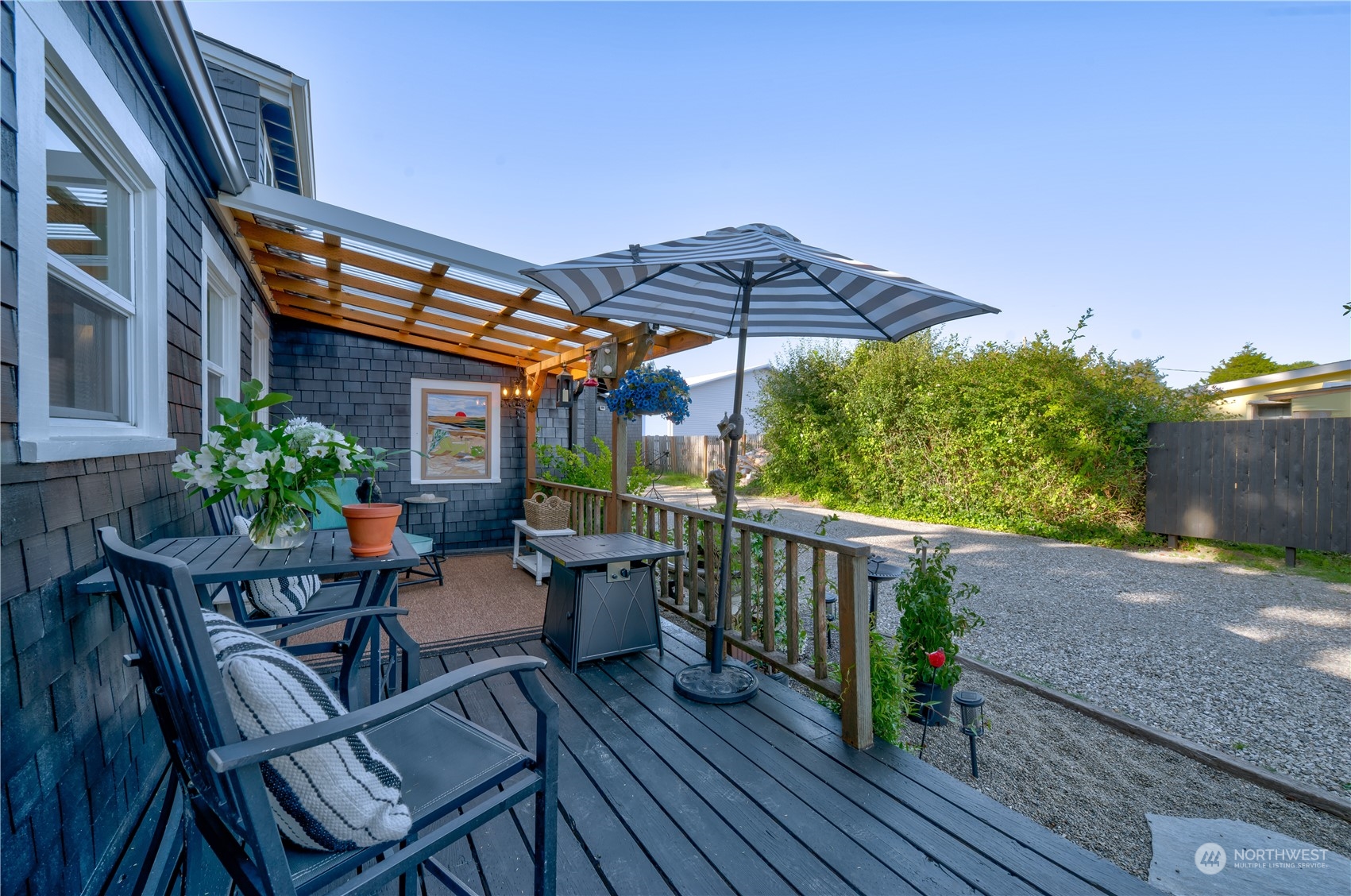 4202 L Place Seaview, WA 98644 - Photo 33 of 39 a view of a patio with table and chairs under an umbrella with wooden floor