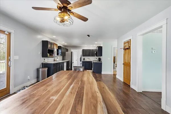 a large kitchen with stainless steel appliances kitchen island granite countertop a refrigerator and a stove top oven