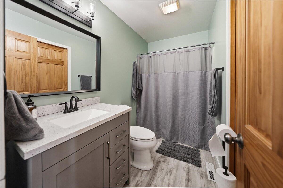 9642 West 1100th Street North Demotte, IN 46310 - Photo 16 of 37 a bathroom with a sink a toilet a mirror and shower curtain