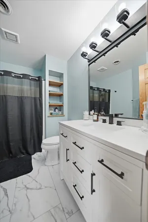 a bathroom with a double vanity sink a mirror and a shower