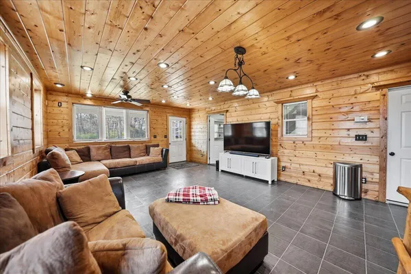 a large white kitchen with granite countertop a sink and dishwasher a stove with wooden cabinets