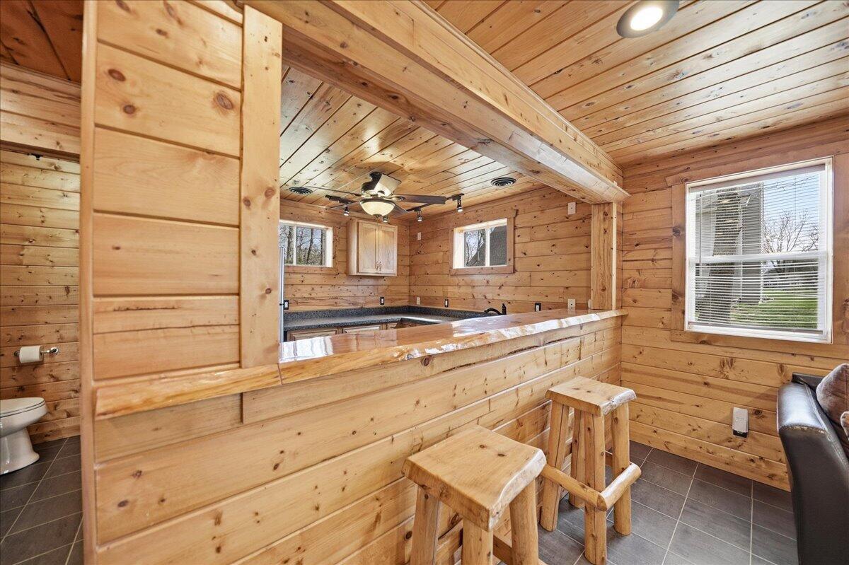 9642 West 1100th Street North Demotte, IN 46310 - Photo 35 of 37 a view of a kitchen with granite countertop chairs and wooden cabinets