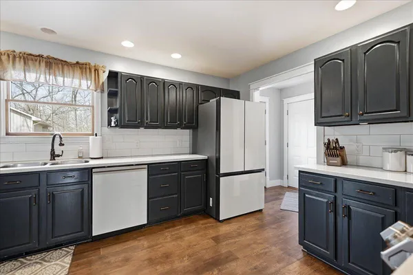 a kitchen with granite countertop a refrigerator stove top oven and sink