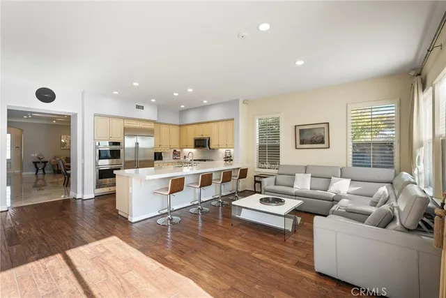 a living room with furniture wooden floor and a large window