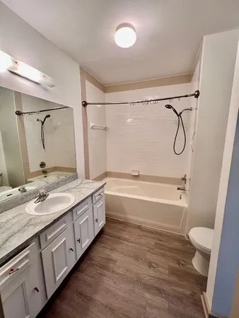 a bathroom with a double vanity sink toilet mirror and shower