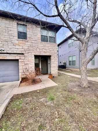 a front view of a house with yard and parking