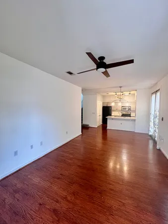 a view of empty room with wooden floor and ceiling fan