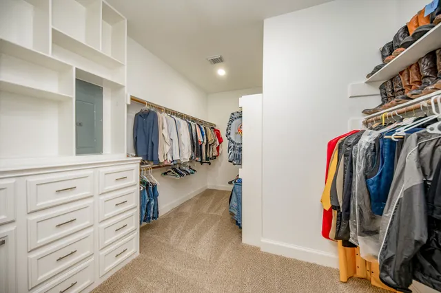 a view of walk in closet with clothes and shoes