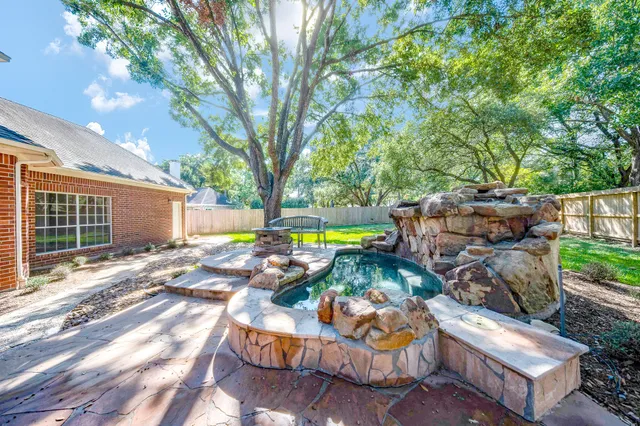 a backyard of a house with garden and outdoor seating