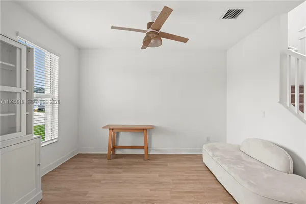 a view of an empty room with a floor to ceiling window and potted plants