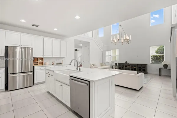 a living room with furniture a chandelier and a dining table