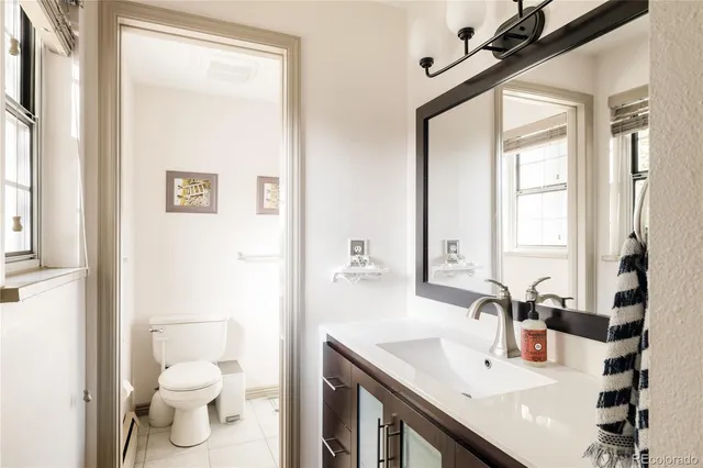 a bathroom with a sink a toilet and a mirror