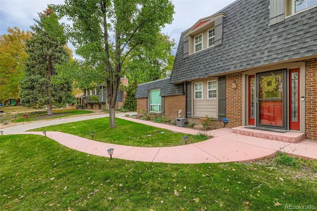 a front view of a house with a yard and trees