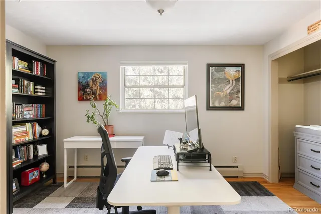 a living room with furniture a bookshelf and a window