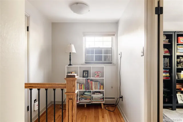 a view of a bedroom with wooden floor and furniture