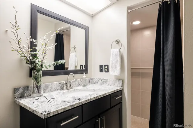 a bathroom with a granite countertop sink and a mirror