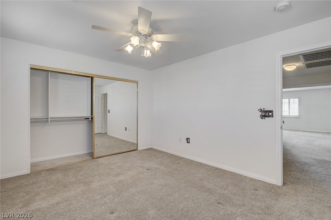 1479 Orange Jubilee Road Henderson, NV 89014 - Photo 26 of 36 A comfortable bedroom with mirrored closet doors and ceiling fan awaits.