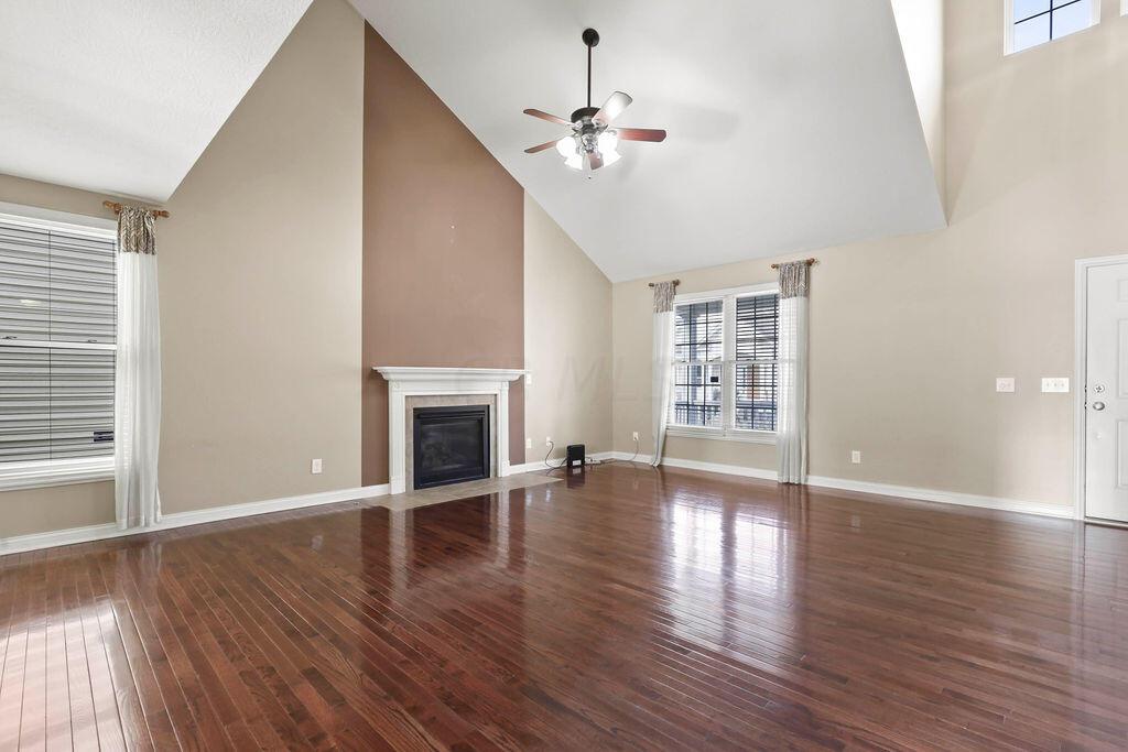 6163 Jennis Road Westerville, OH 43081 - Photo 7 of 44 • Hardwood flooring
• Tan painted walls
• Vaulted ceiling
• Lighted ceiling fan
• Gas log fireplace with
mantle
• Closet under stairs
• 2” blinds
• Drapes remain