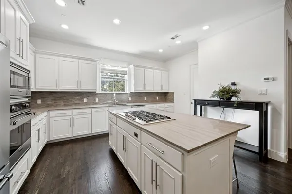 a kitchen with granite countertop a stove sink and cabinets