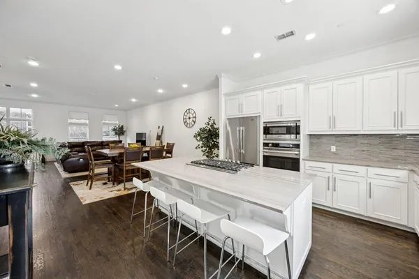 a large kitchen with kitchen island a dining table and chairs