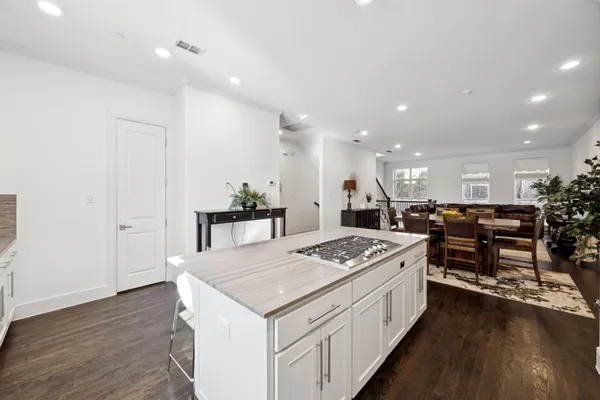 a kitchen with a table chairs stove and wooden floor