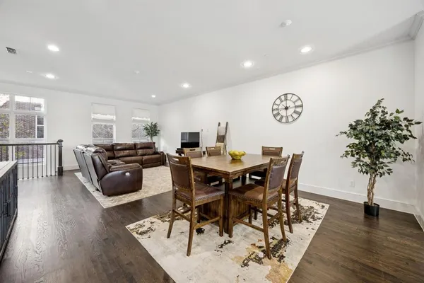 a view of a dining room with furniture wooden floor and a potted plant