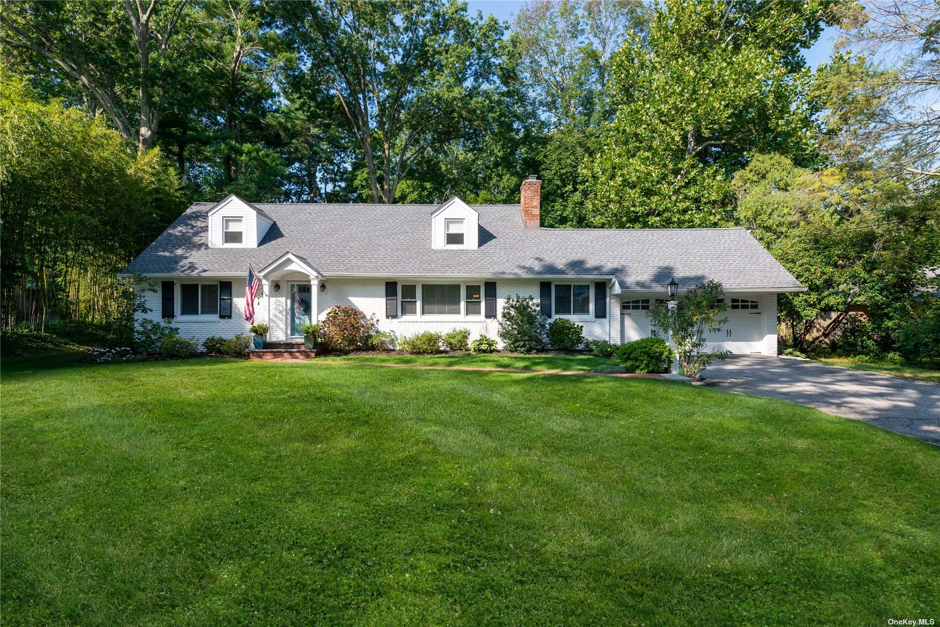 11 Coot Road Locust Valley, NY 11560 - Photo 1 of 1 a front view of a house with a yard table and chairs