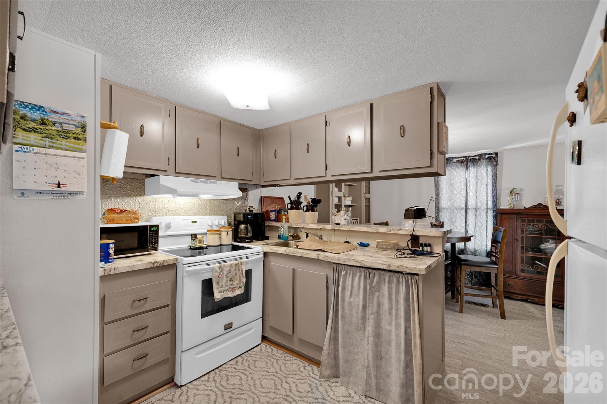 2187 McBee Highway Bethune, SC 29009 - Photo 11 of 38 a kitchen with stainless steel appliances granite countertop a stove top oven a refrigerator a sink and dishwasher with white cabinets