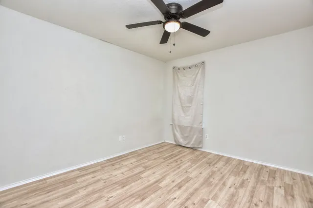 an empty room with a ceiling fan and carpet