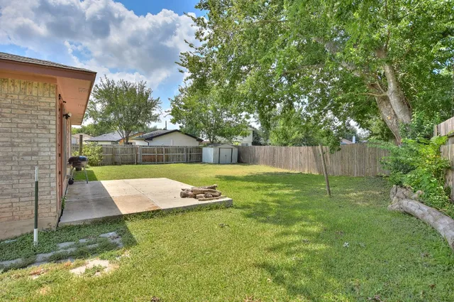 a view of a backyard with table and chairs and wooden fence