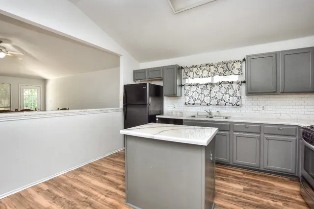 a kitchen with stainless steel appliances granite countertop a sink stove and refrigerator