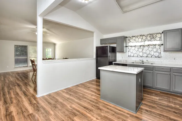 a kitchen with a sink cabinets and wooden floor