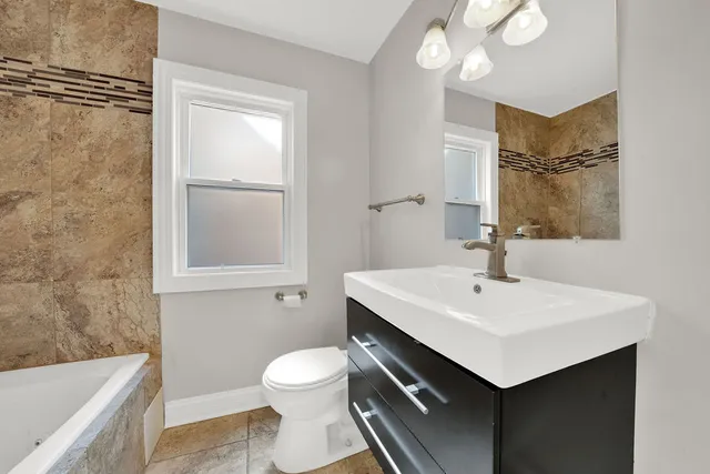 a bathroom with a sink toilet and mirror