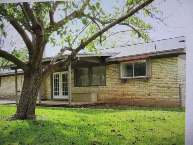 a brick house with a tree in front of a house