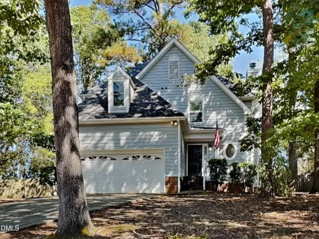 a view of a house with a tree next to a yard