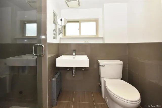 a bathroom with a toilet sink and mirror