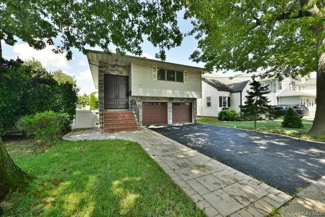 a front view of a house with a garden and yard
