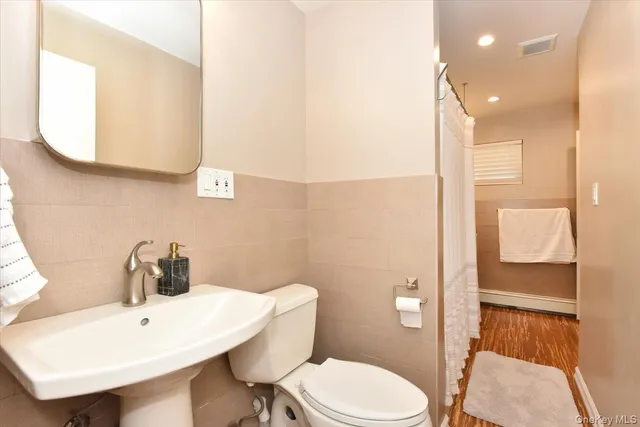 a bathroom with a toilet a sink and mirror