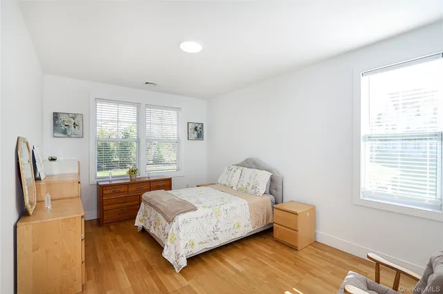 a bedroom with a bed wooden floor and window