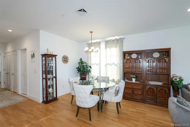 a dining room with furniture potted plants and wooden floor