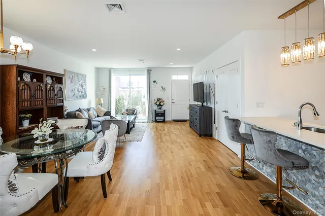 a large kitchen with sink a refrigerator and chairs