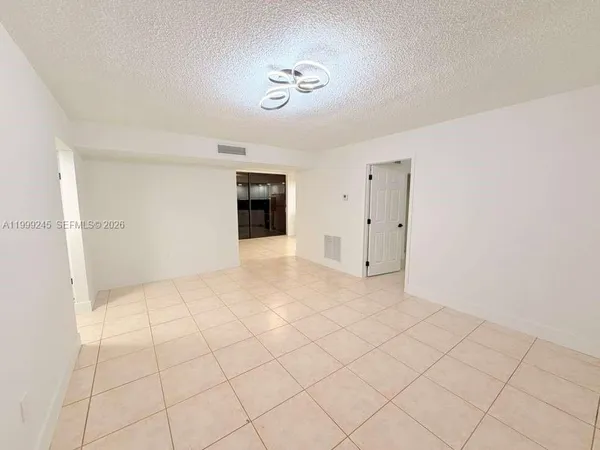 a view of hallway with chandelier and view of kitchen