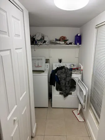 a utility room with cabinets and washer