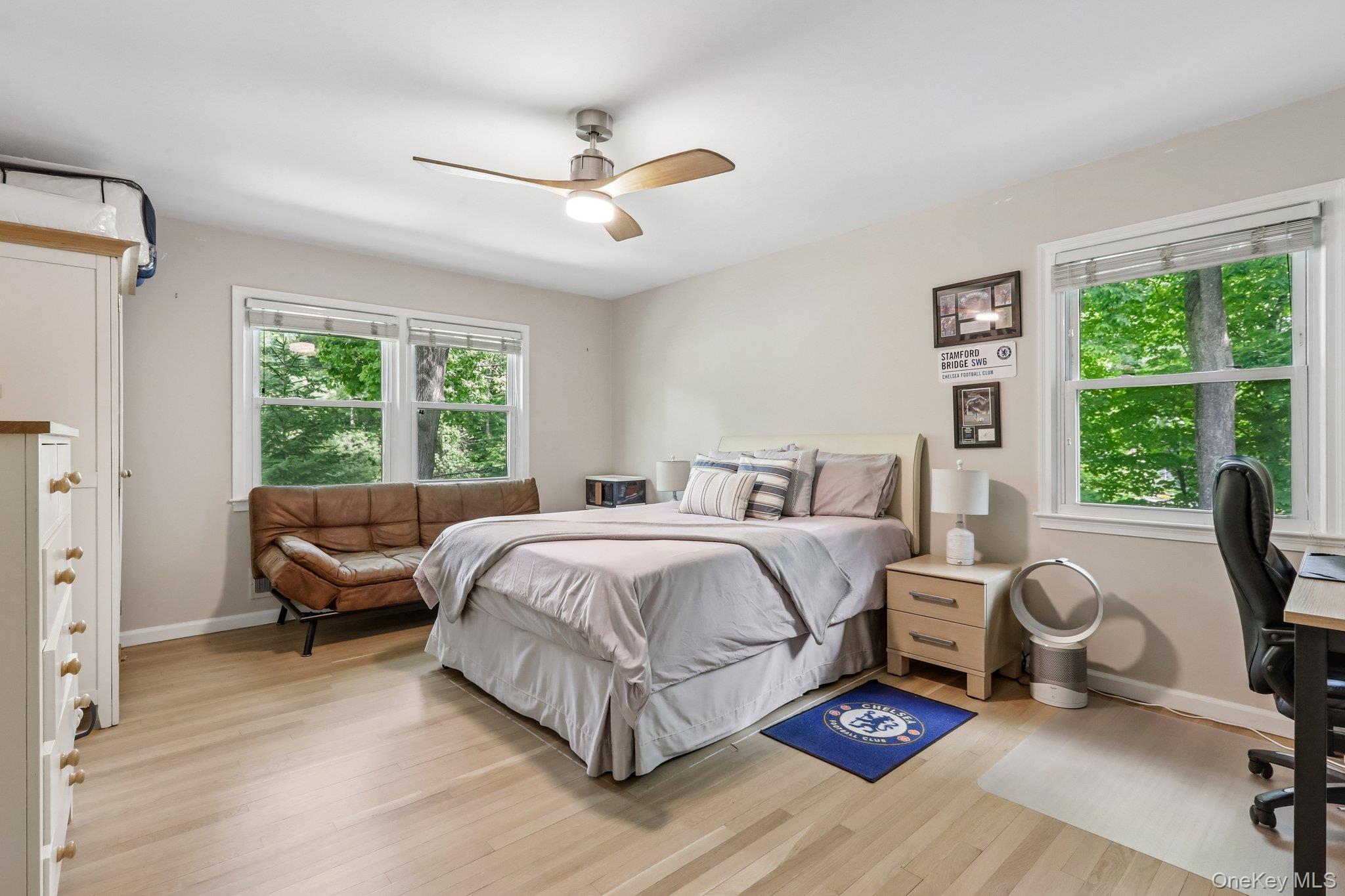 62 Mohegan Road Larchmont, NY 10538 - Photo 33 of 46 a spacious bedroom with a bed a chandelier and a window