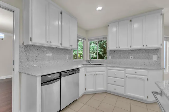 a kitchen with cabinets appliances a sink and a window