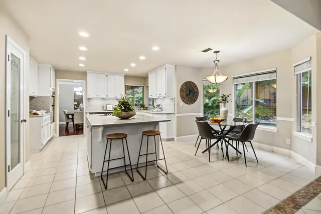 a kitchen with a dining table chairs and large cabinets