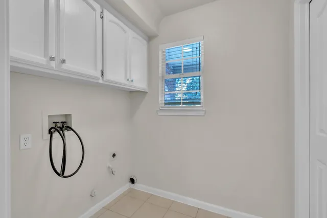 a bathroom with white cabinets and a window