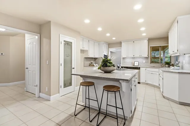 a kitchen with stainless steel appliances kitchen island granite countertop a refrigerator and cabinets